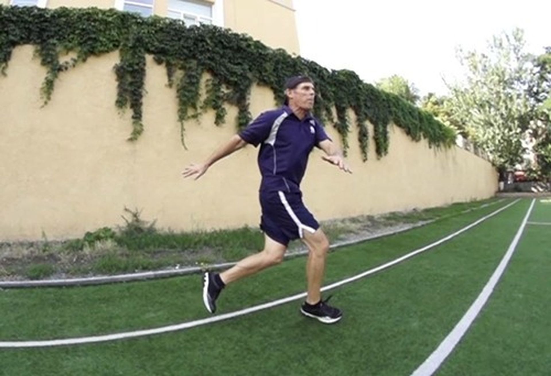 Tom Wright in a blue shirt and shorts is running on a soccer field