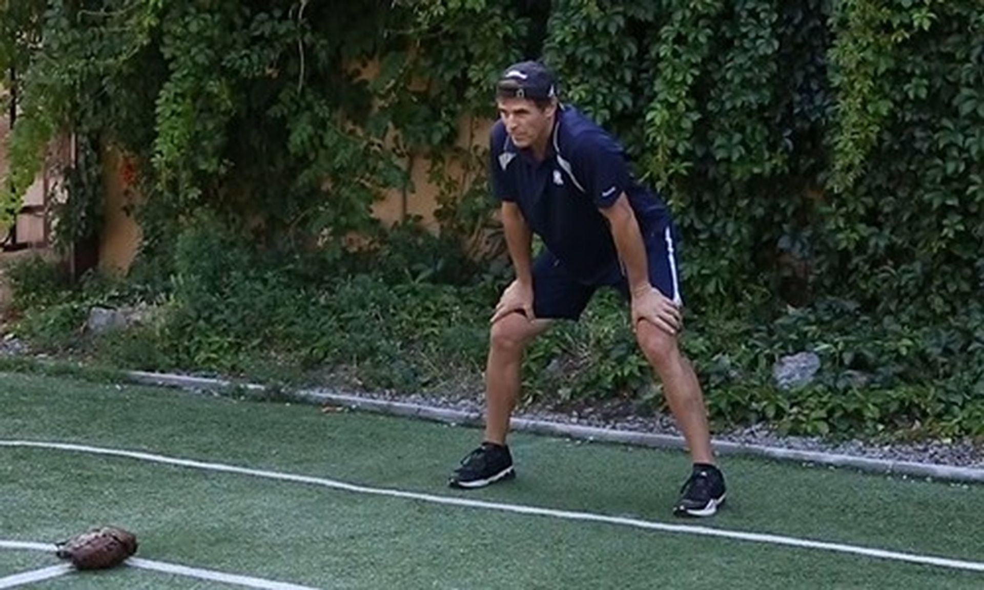 Tom Wright is standing on a football field with his hands on his knees.