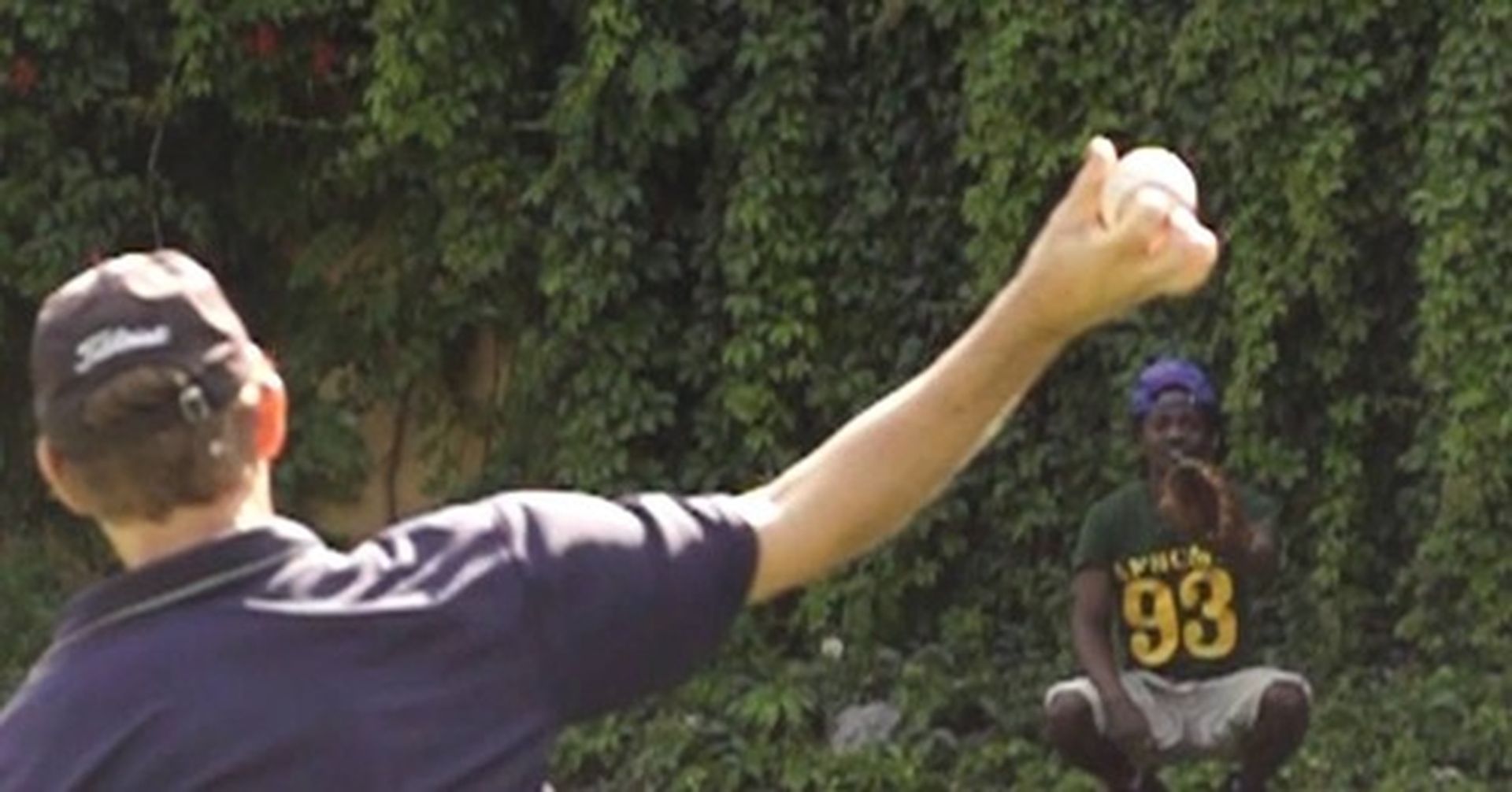 A man wearing a number 93 jersey is throwing a baseball