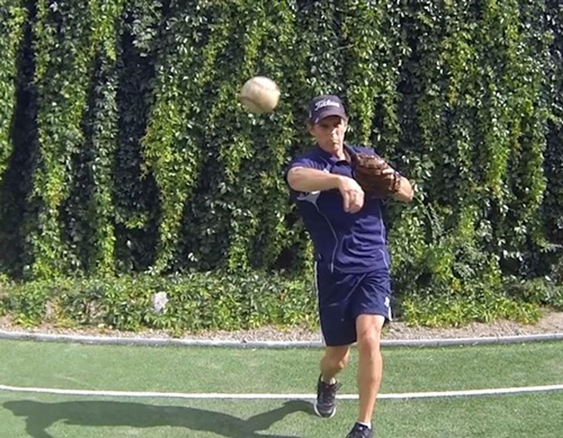 Tom Wright in a blue shirt is catching a baseball
