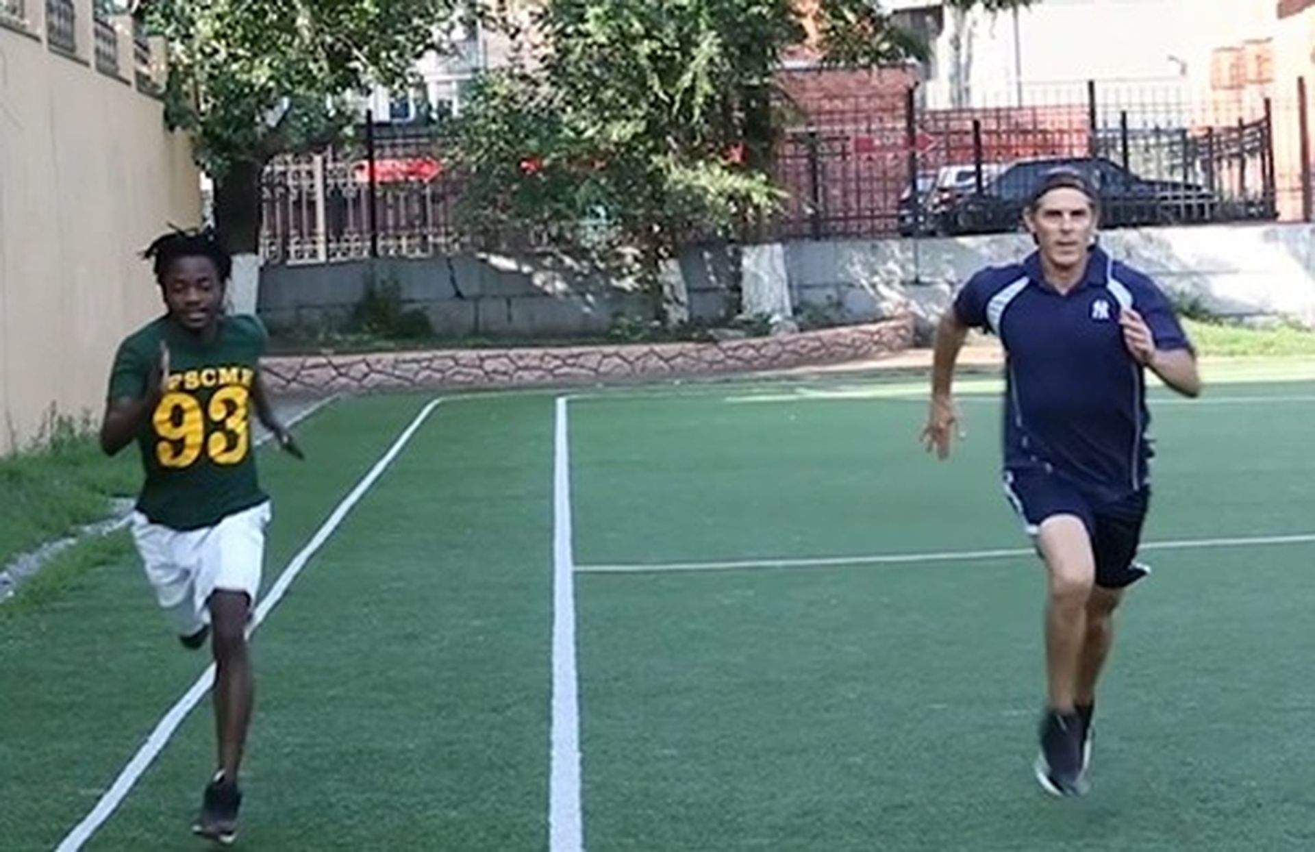 A man wearing a green jersey with the number 93 on it is running with Tom Wright