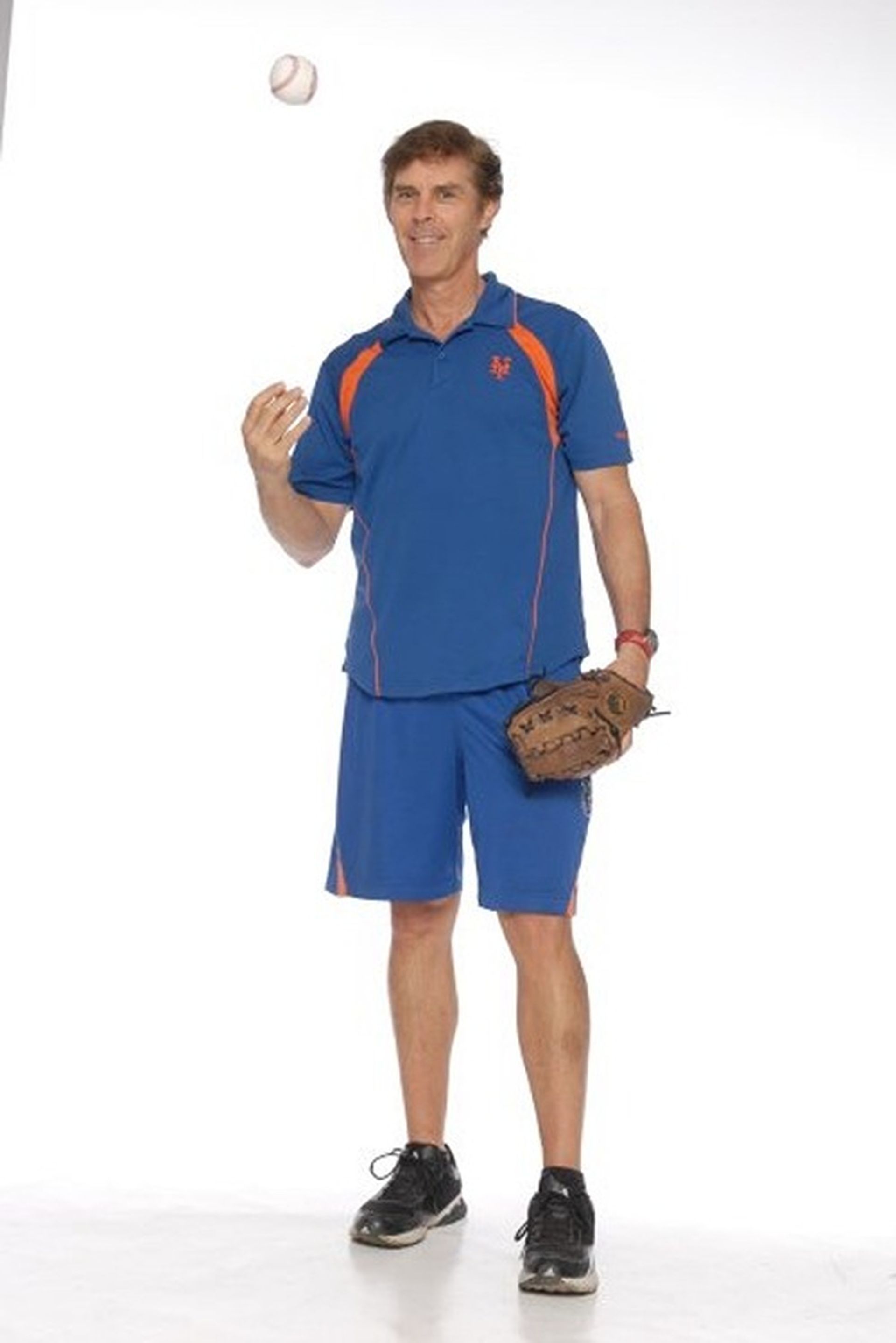 Tom Wright in a blue shirt is throwing a baseball in the air