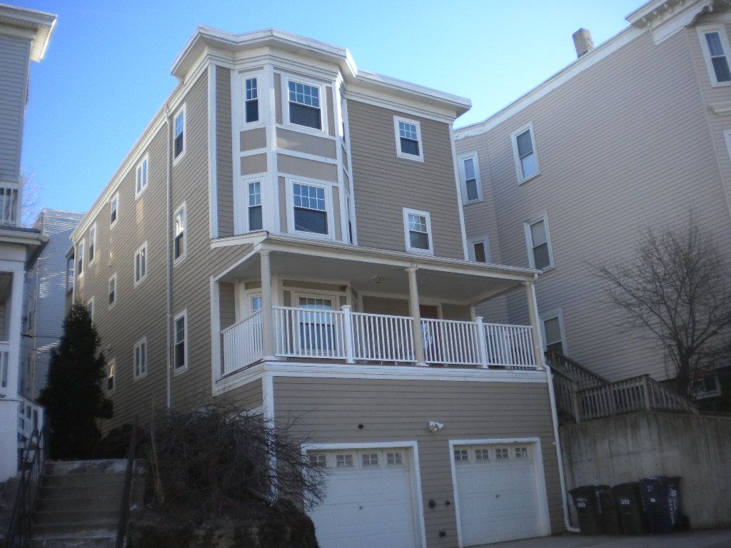 A large house with a balcony and two garages