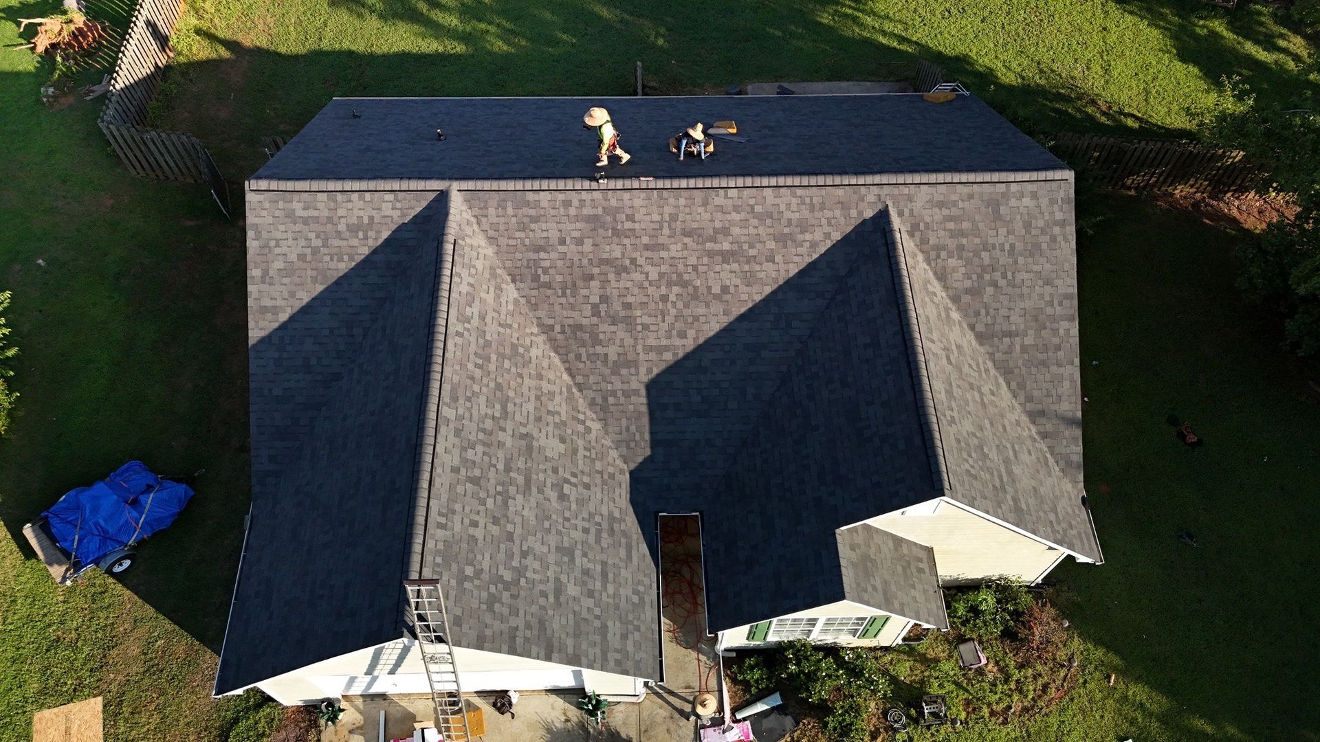 An aerial view of a house with a new roof being installed.