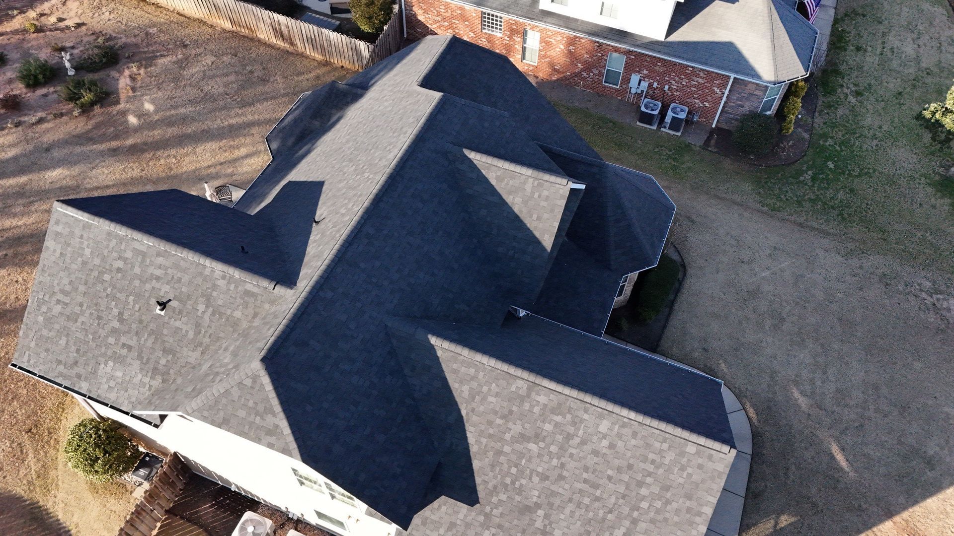 An aerial view of a house with a black roof.