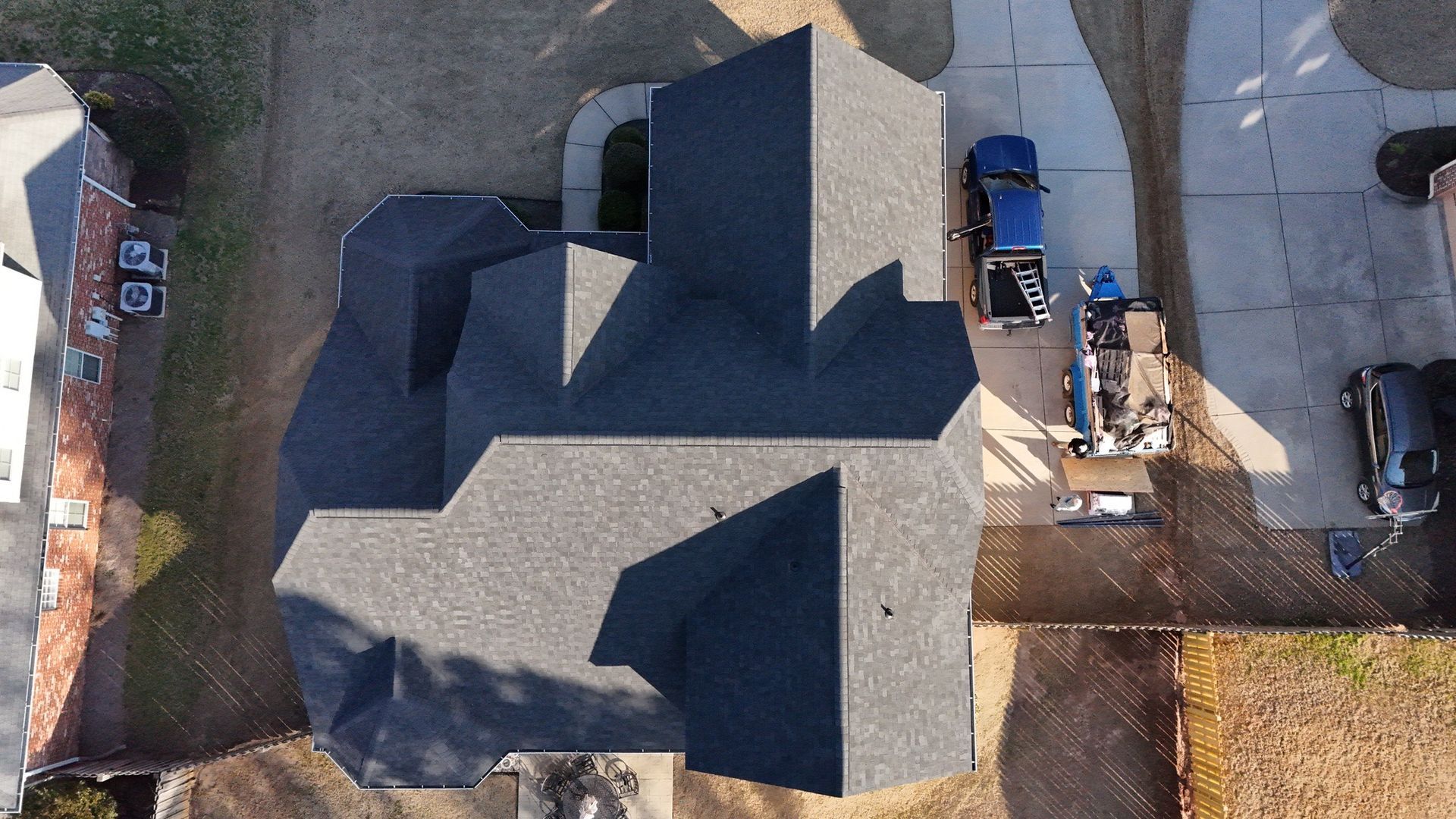 An aerial view of a house with a blue truck parked in front of it.