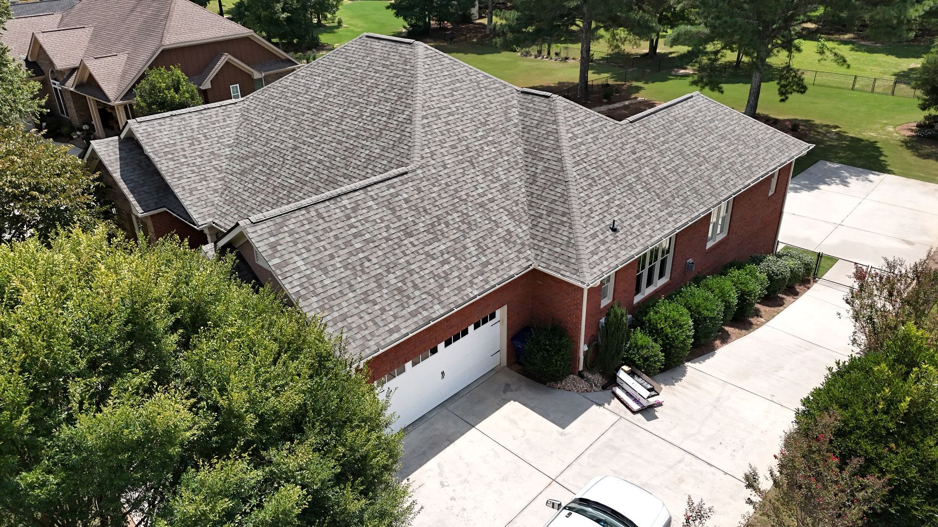 An aerial view of a brick house with a car parked in front of it.