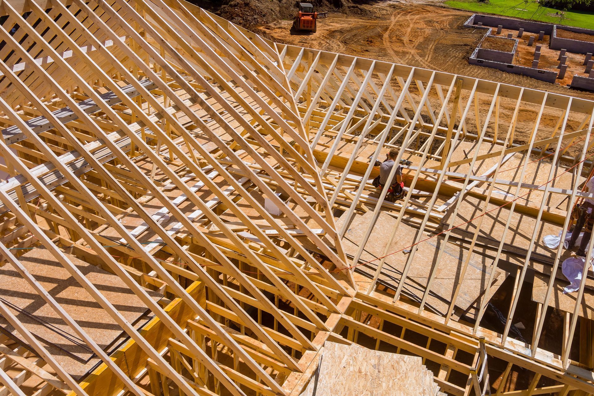 A large wooden structure is being built on a construction site.