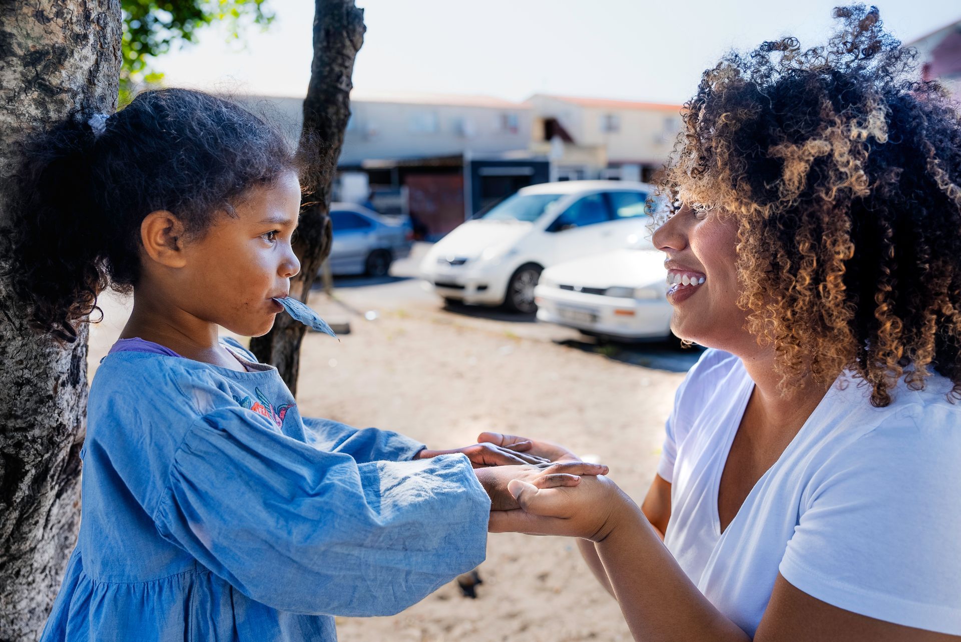 A woman is holding the hand of a little girl.