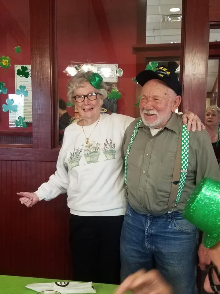 A man and a woman are posing for a picture in a room.