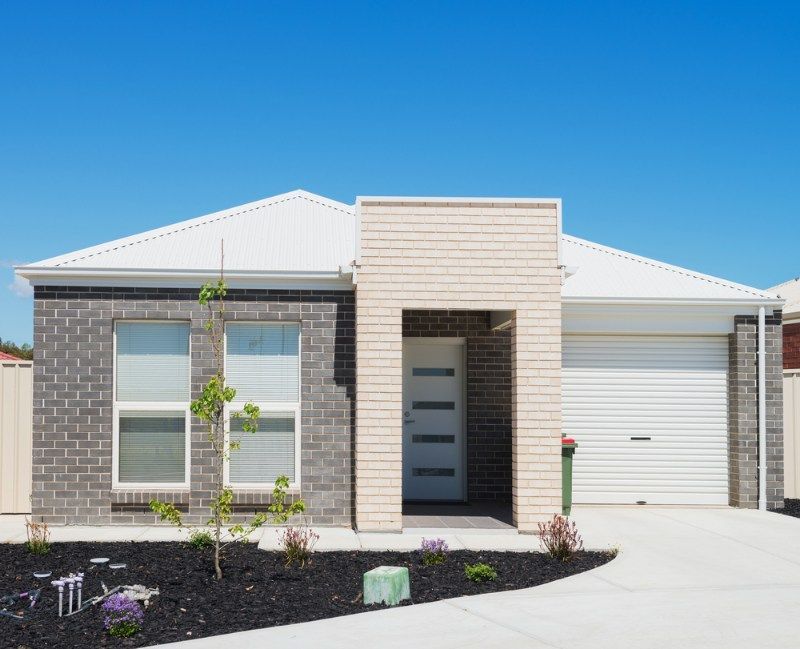 Brick House With a White Roof and a White Garage Door — Coffs Garage Doors & Motors in Coffs Harbour, NSW
