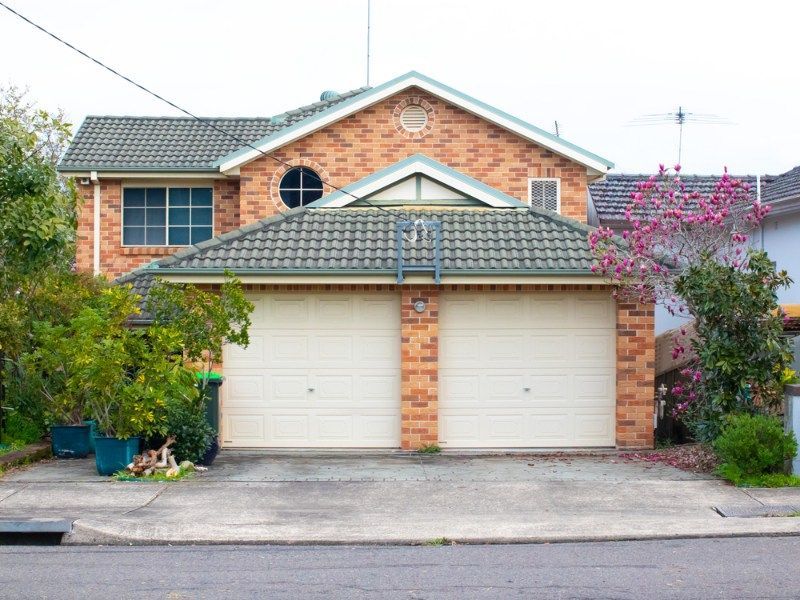 Large Brick House With Two White Garage Doors — Coffs Garage Doors & Motors in Bellingen, NSW