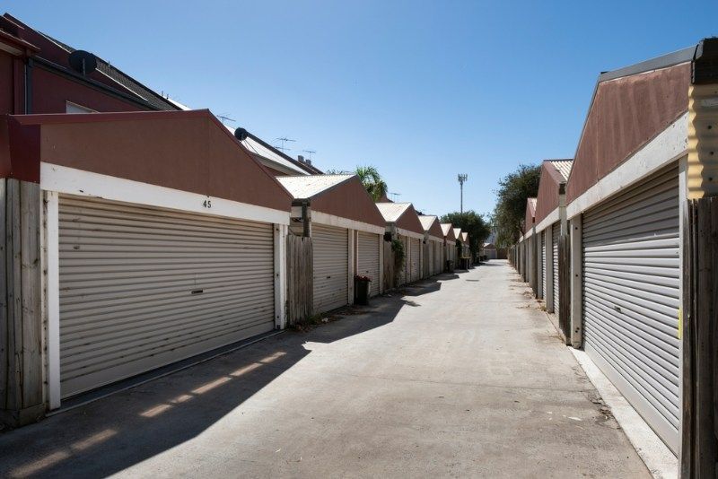 Row of Garage Doors Are Lined Up on the Side of a Road — Coffs Garage Doors & Motors in Bellingen, NSW