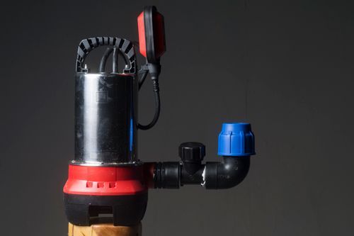 A Red And Black Submersible Water Pump Is Sitting On Top Of A Wooden Pole - Oklahoma City, OK - Total Pump & Supply