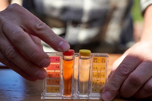 A Person Is Holding A Test Tube With A Red Cap - Oklahoma City, OK - Total Pump & Supply