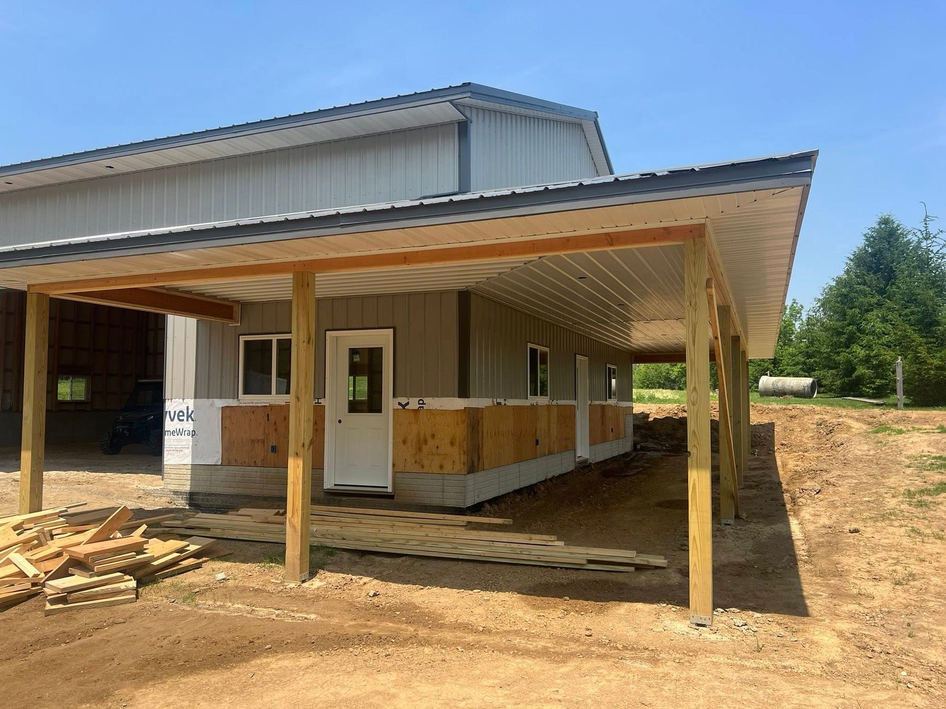 A pole barn with a covered porch and a white door