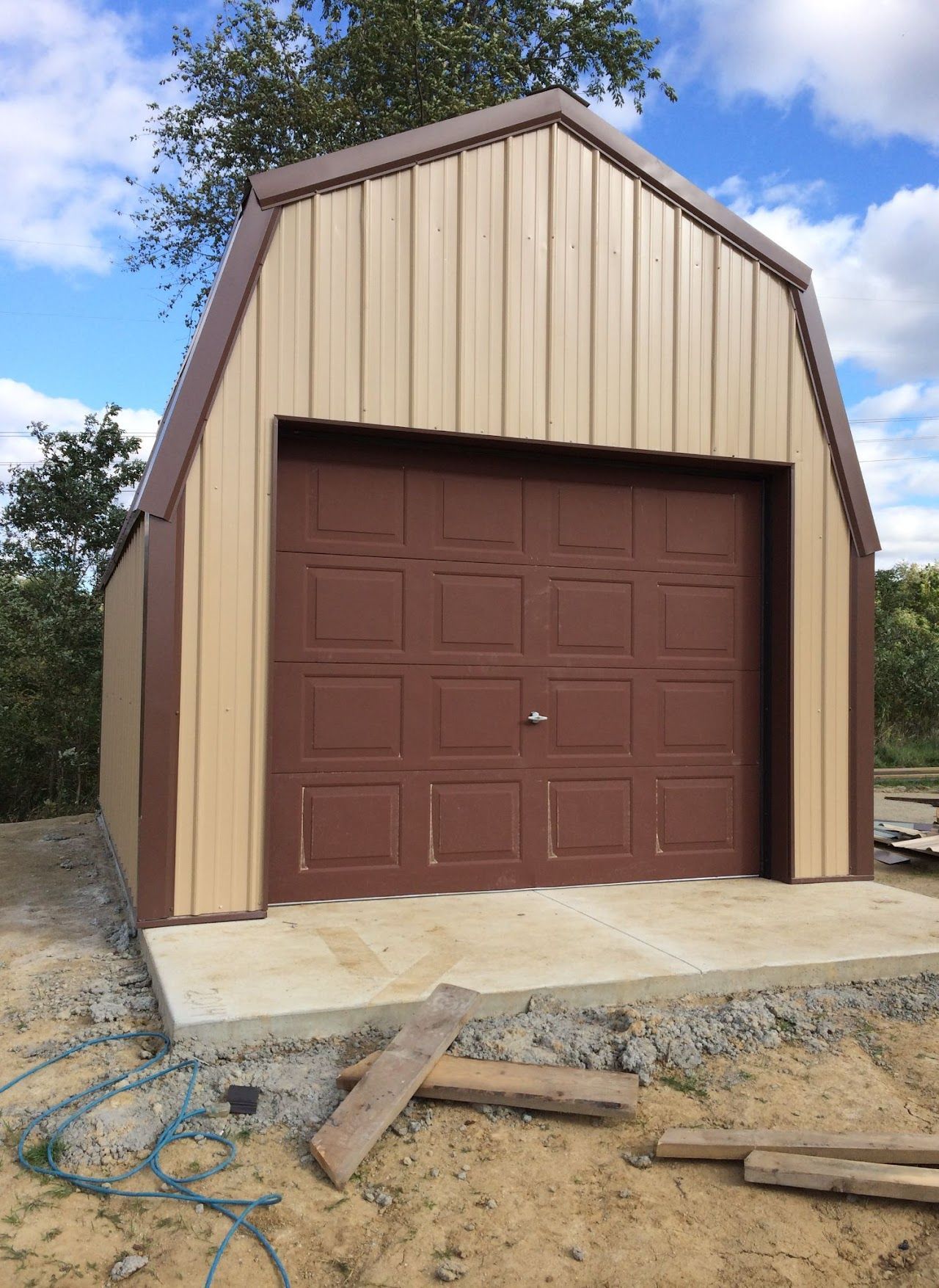 A barn shaped garage with a brown door