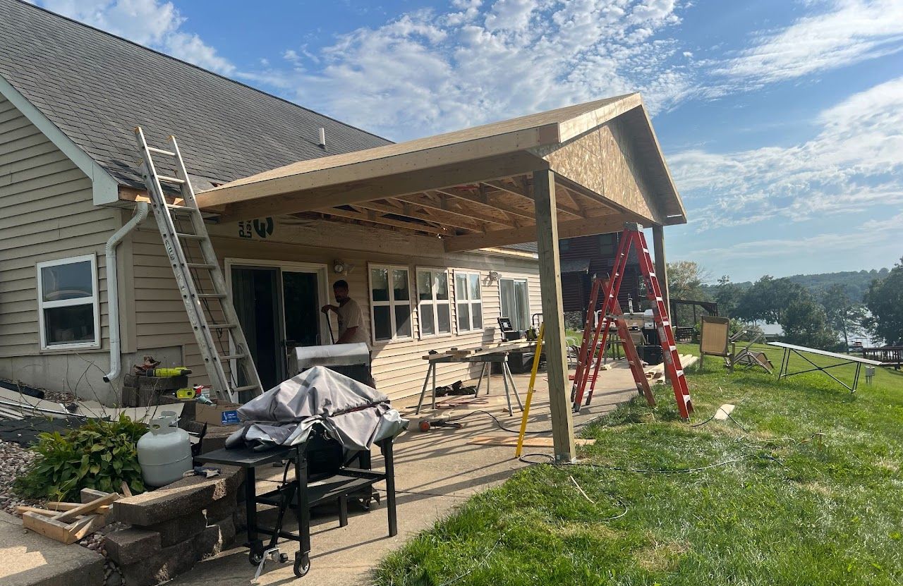 A house with a roof that is being built and a ladder in front of it.