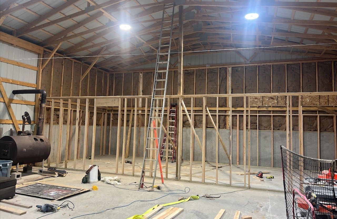 A large pole barn under construction with a ladder in the middle