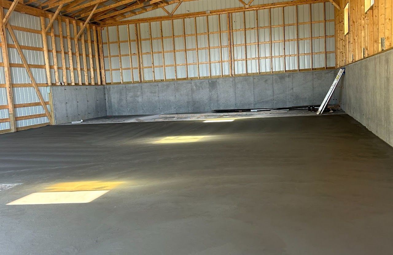 An interior of a pole barn with concrete floor and wooden walls