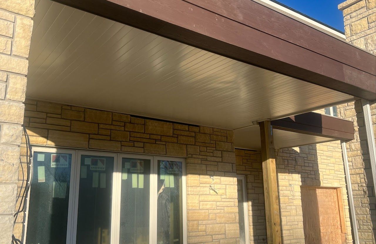 A brick building with a brown roof and white windows