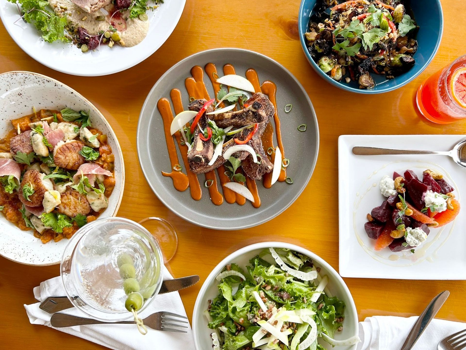 A table topped with plates of food and bowls of salad.