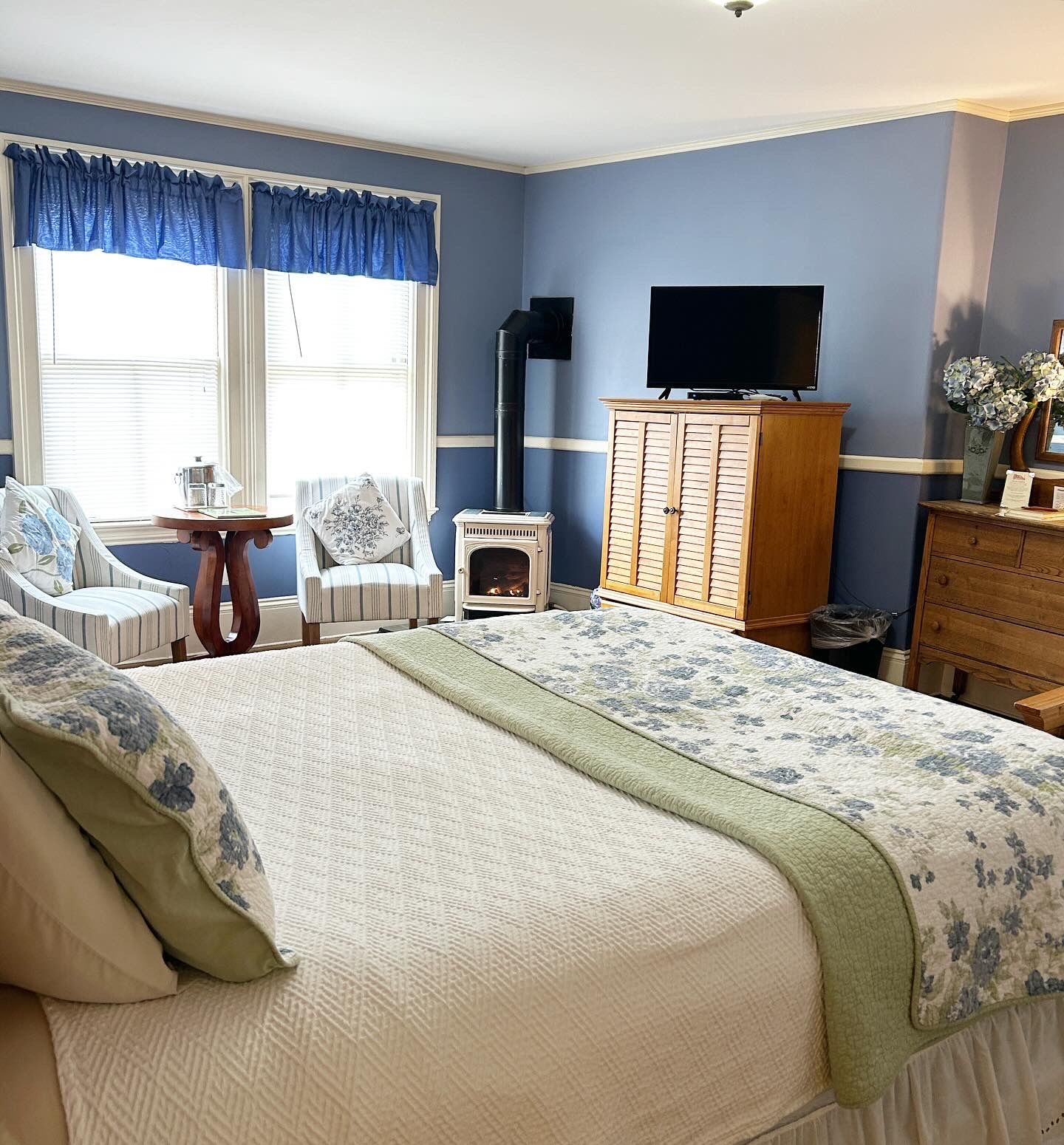 A bedroom with a king size bed and a flat screen tv