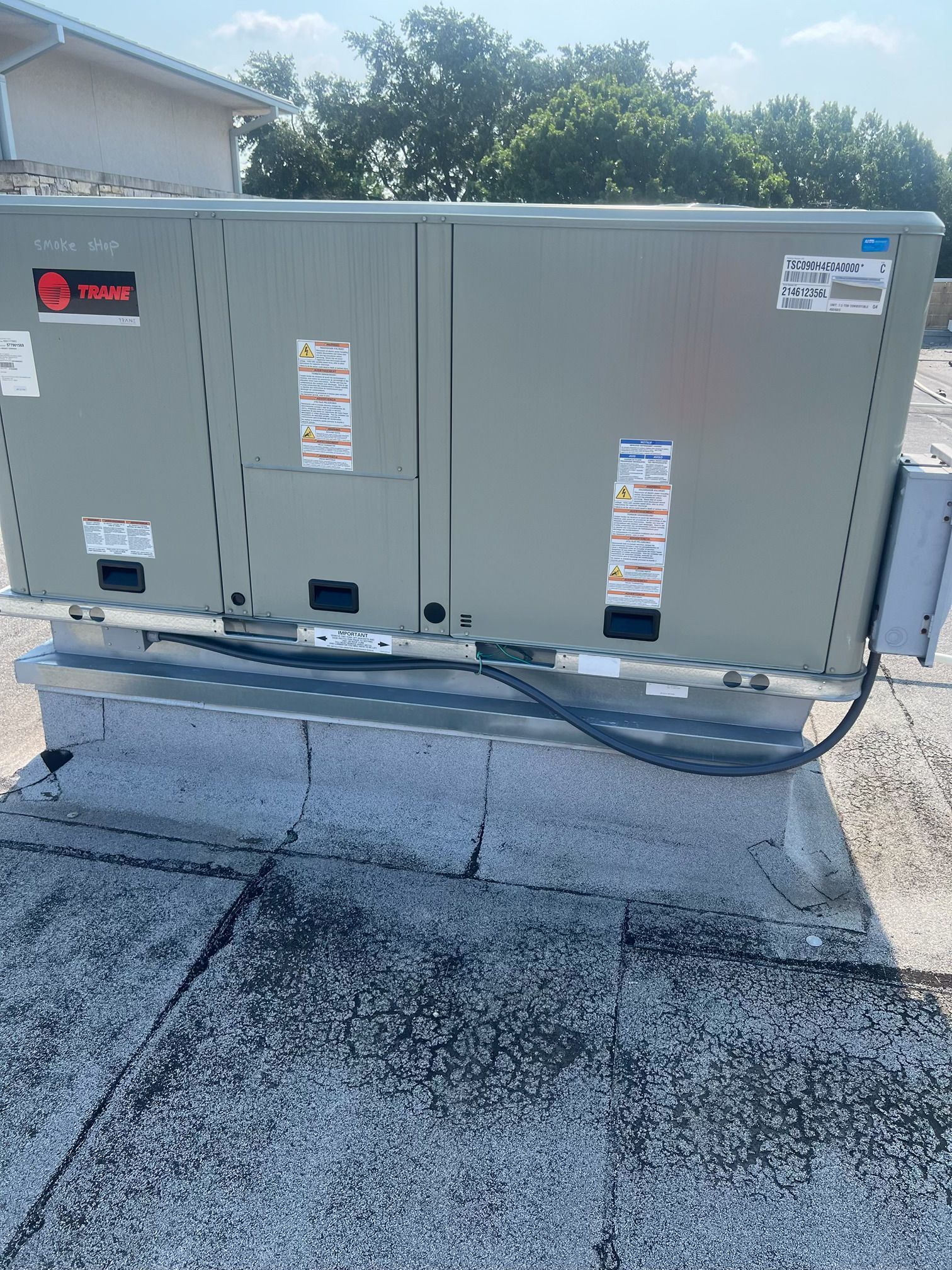 A large air conditioner is sitting on top of a roof.