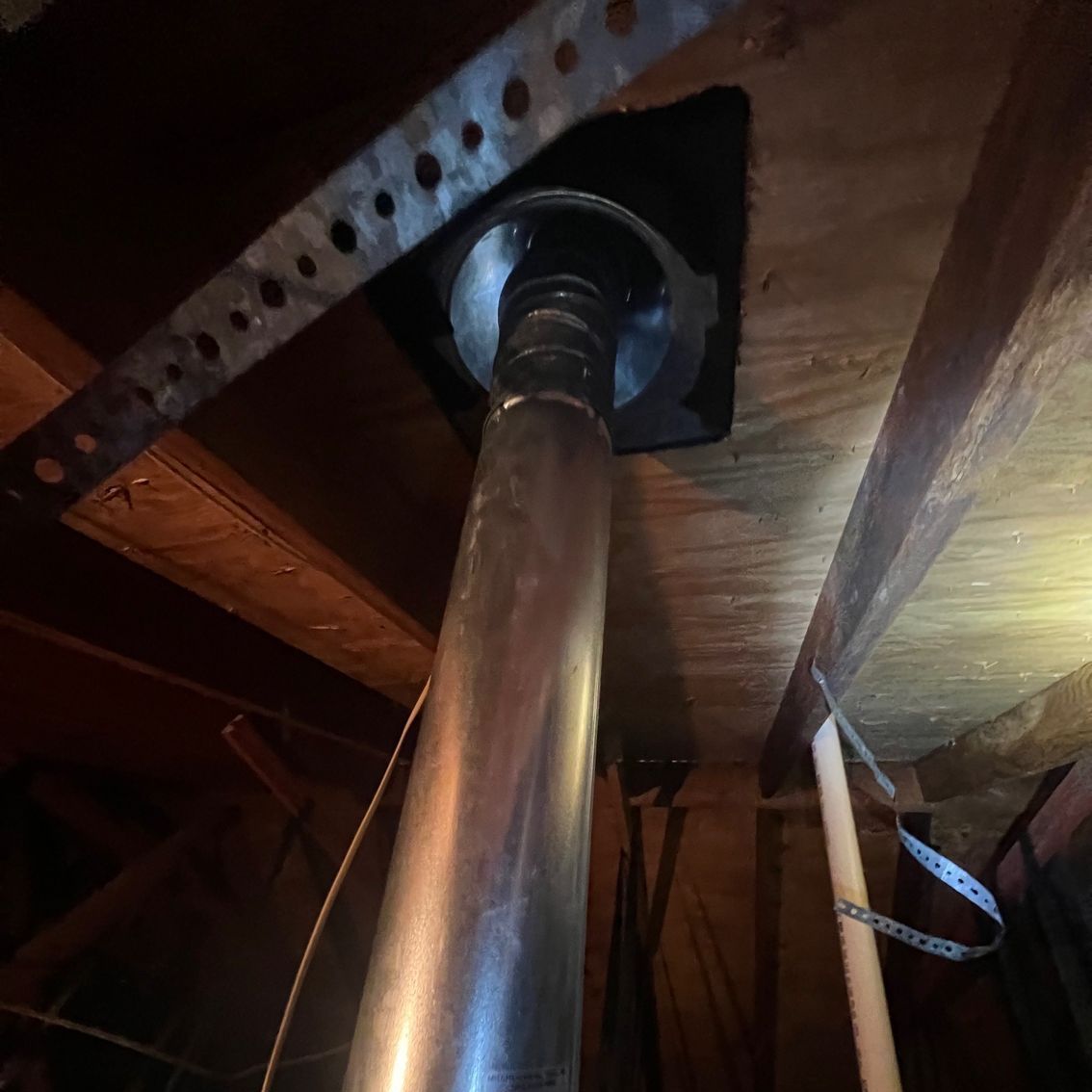 A metal pipe is hanging from the ceiling of a room.