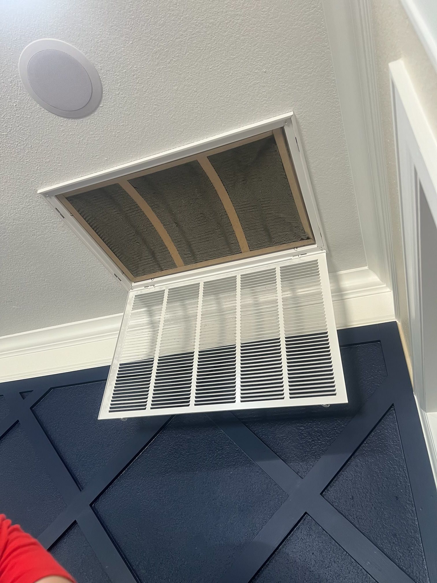 A white air filter is hanging from the ceiling in a room.