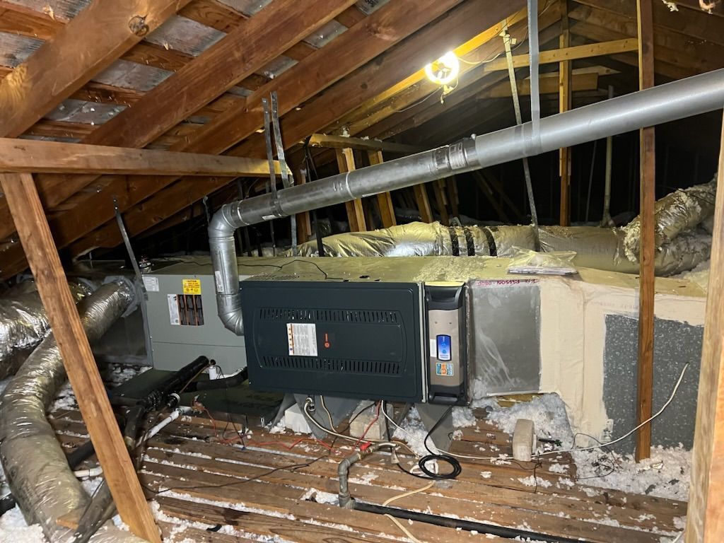 An air conditioner is sitting in the attic of a house.