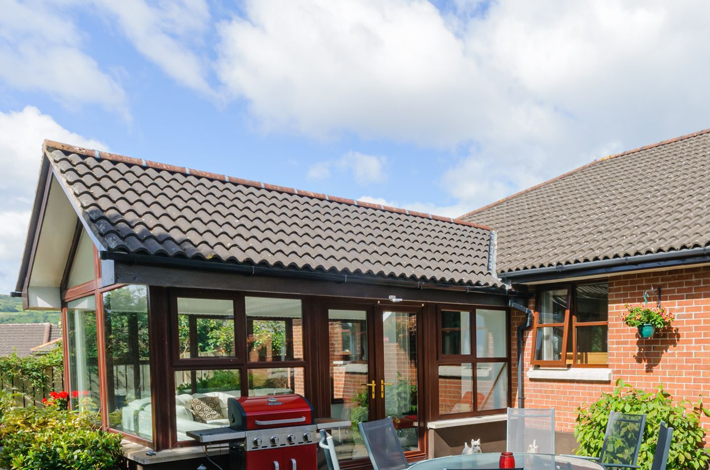 A house with a bbq and a table in front of it.