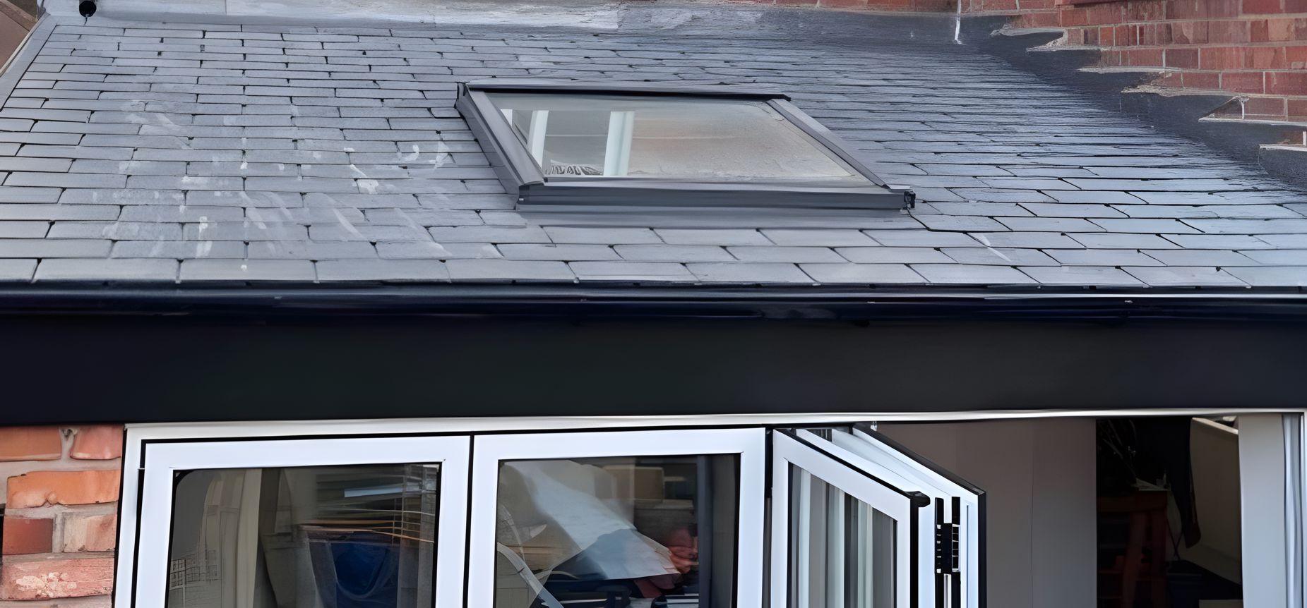 A window with a skylight on the roof of a house.