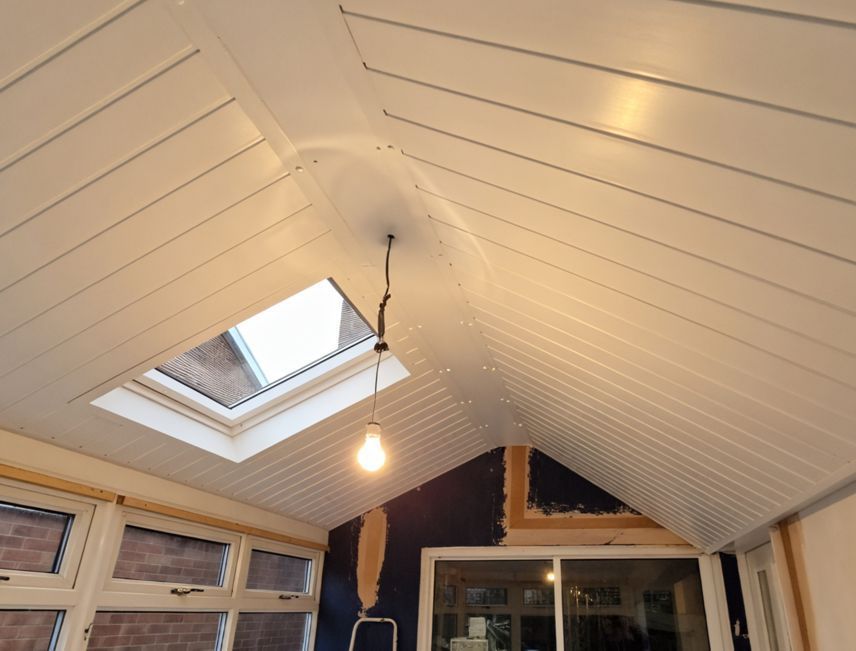 A ceiling with a skylight and a light hanging from it