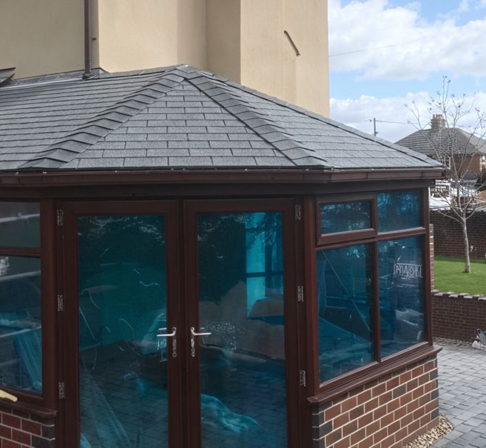 A conservatory with a slate roof and blue glass doors