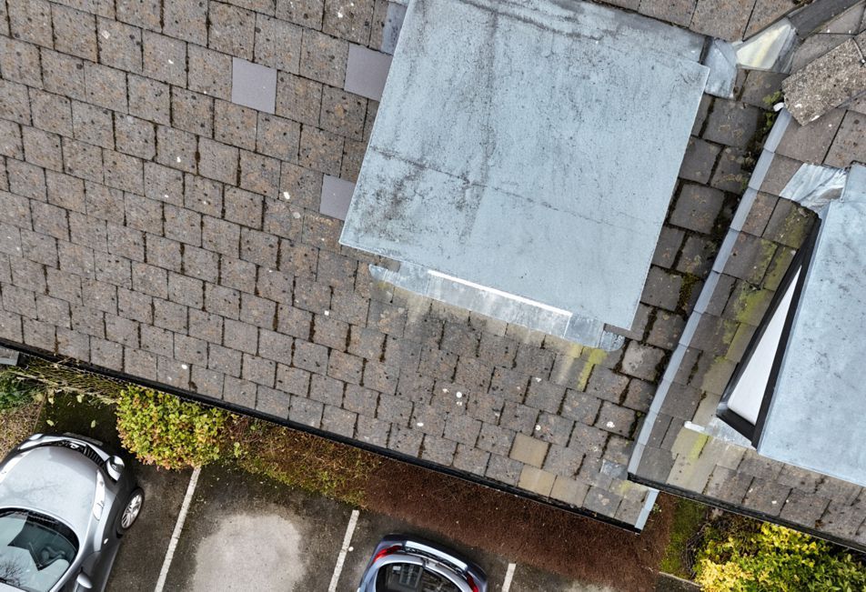 An aerial view of a parking lot with cars parked in front of a building.