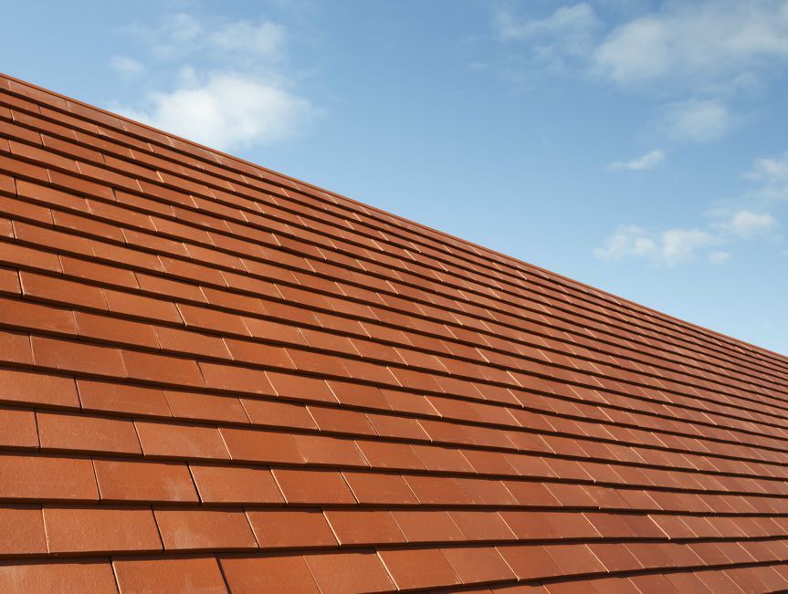 A red tiled roof with a blue sky in the background