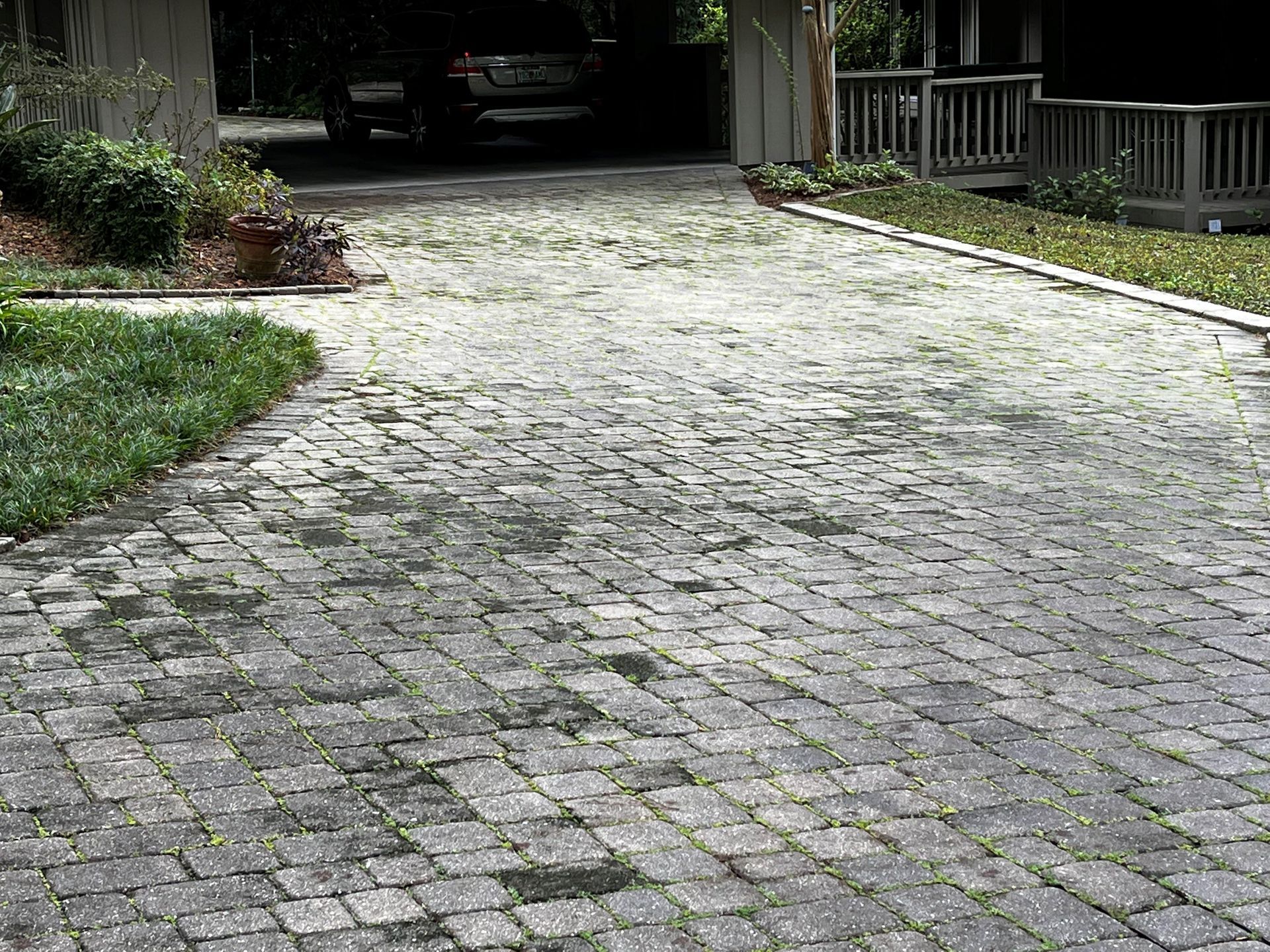 A car is parked in a driveway next to a house.