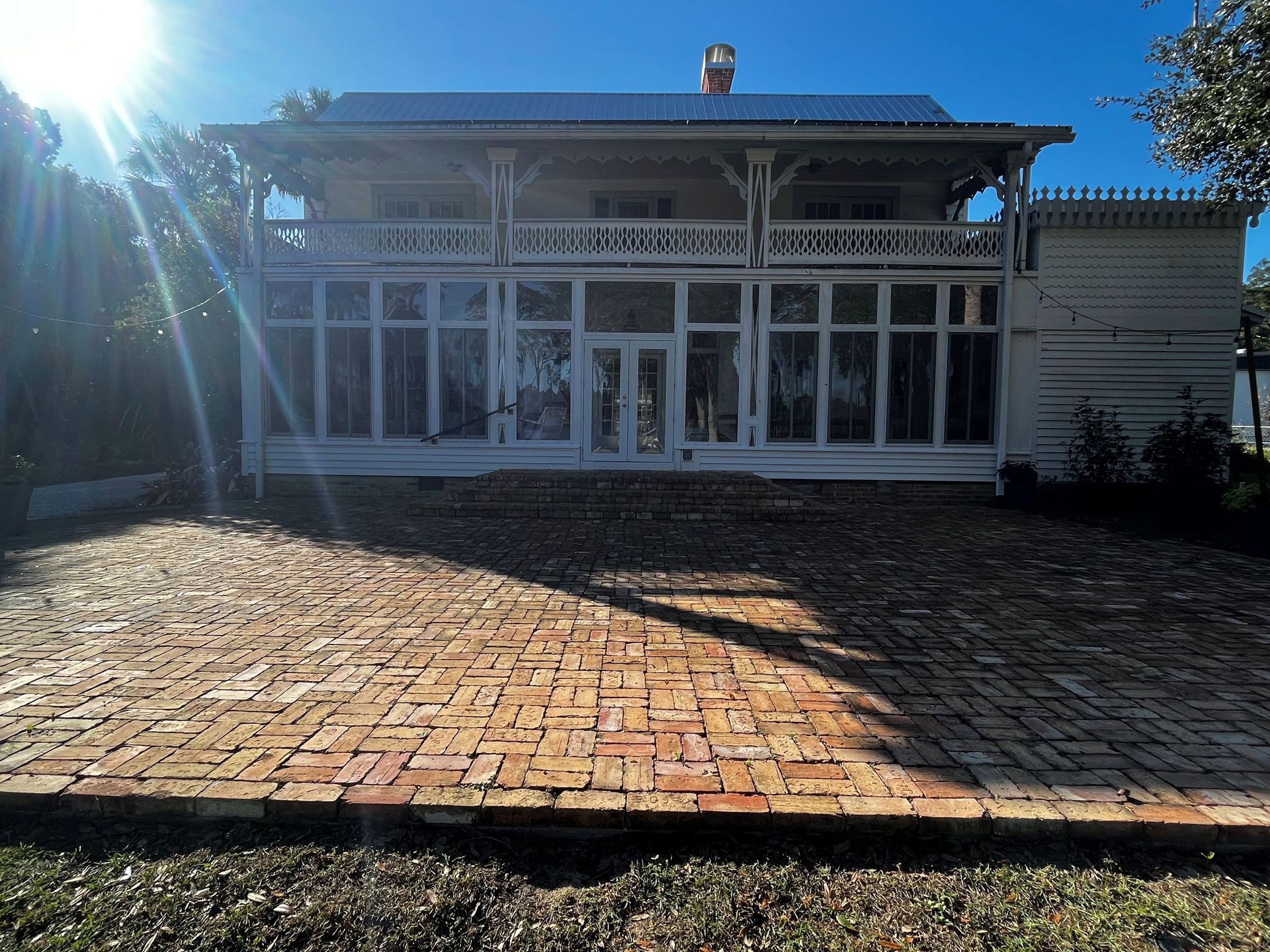 A white house with a brick driveway in front of it