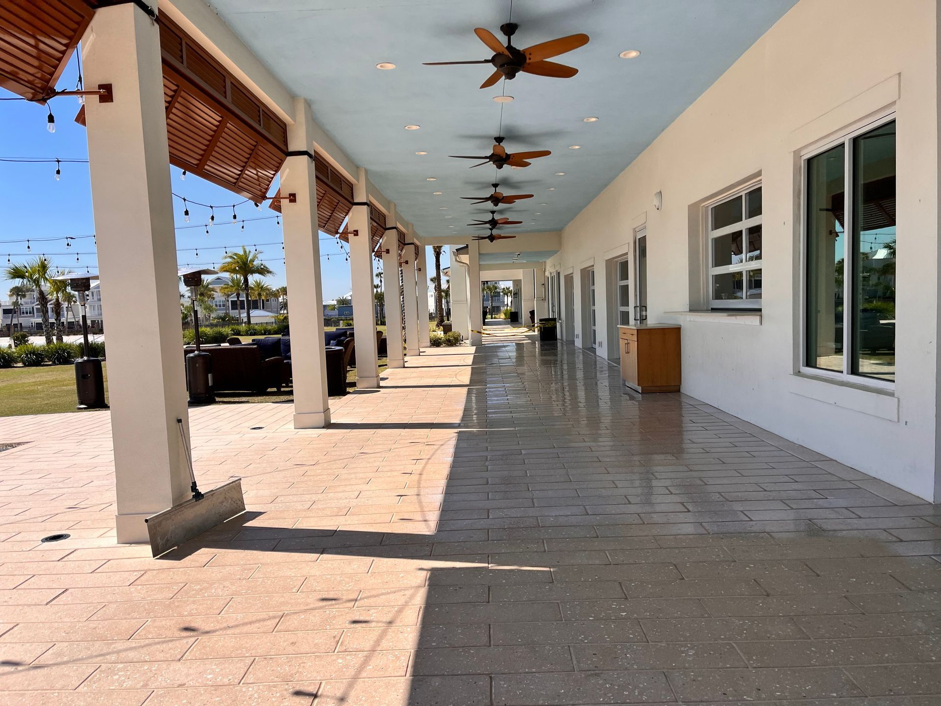 A long hallway with columns and ceiling fans