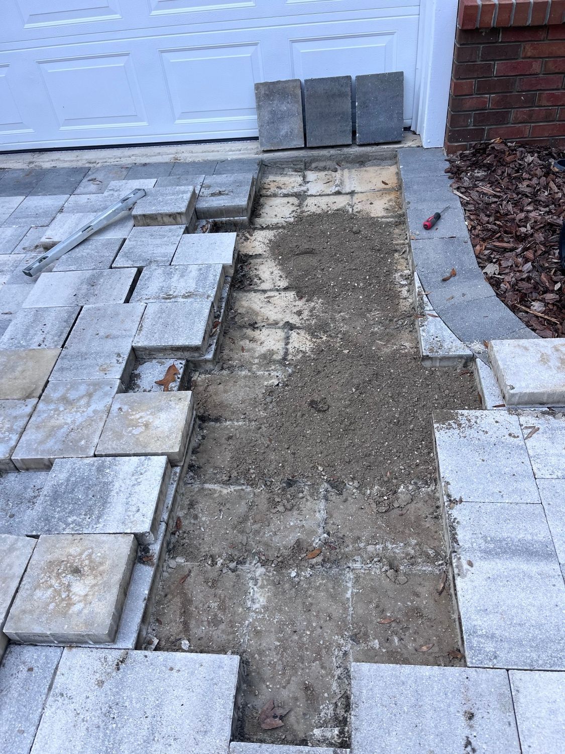 A brick fire pit is being built on a patio.