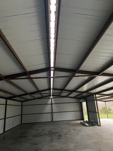 A gray house with a white garage door and a porch.