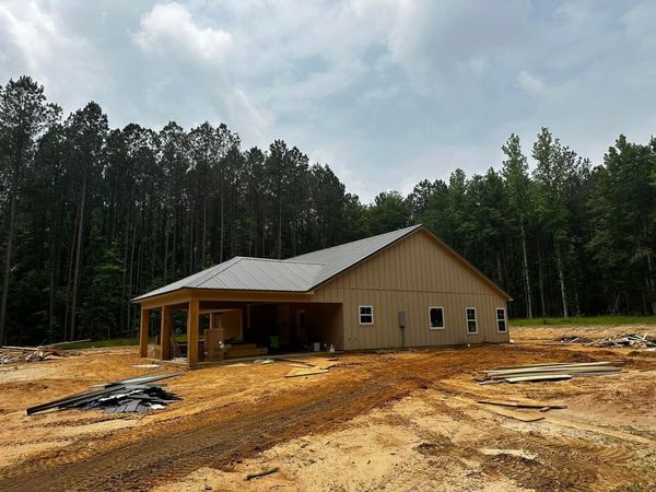 A gray house with a white garage door and a porch.