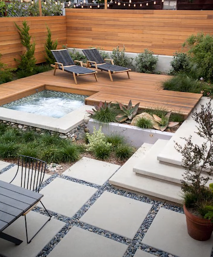 Construction workers spreading wet concrete with tools on a job site.