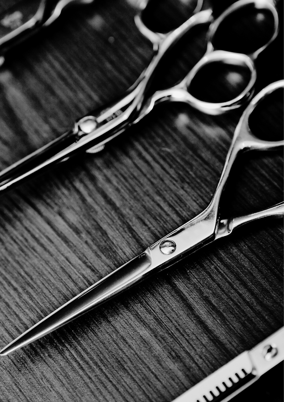 A pair of scissors sitting on top of a wooden table.