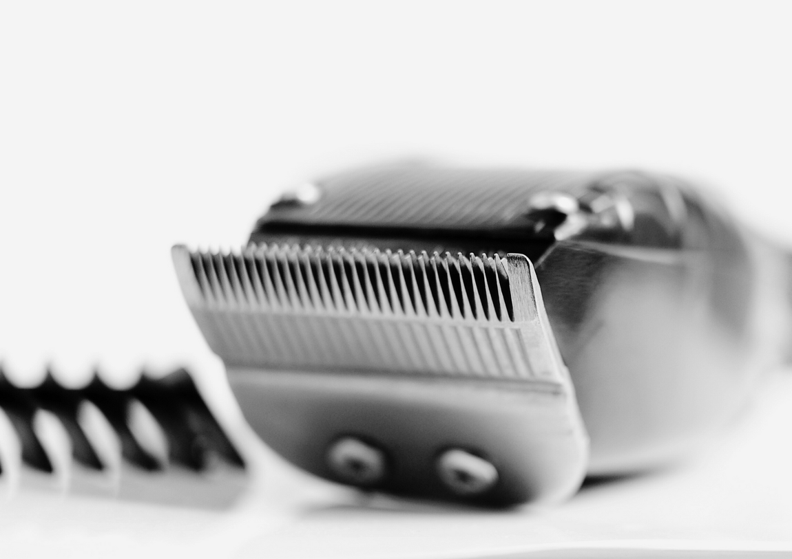 A close up of a hair clipper on a white surface.