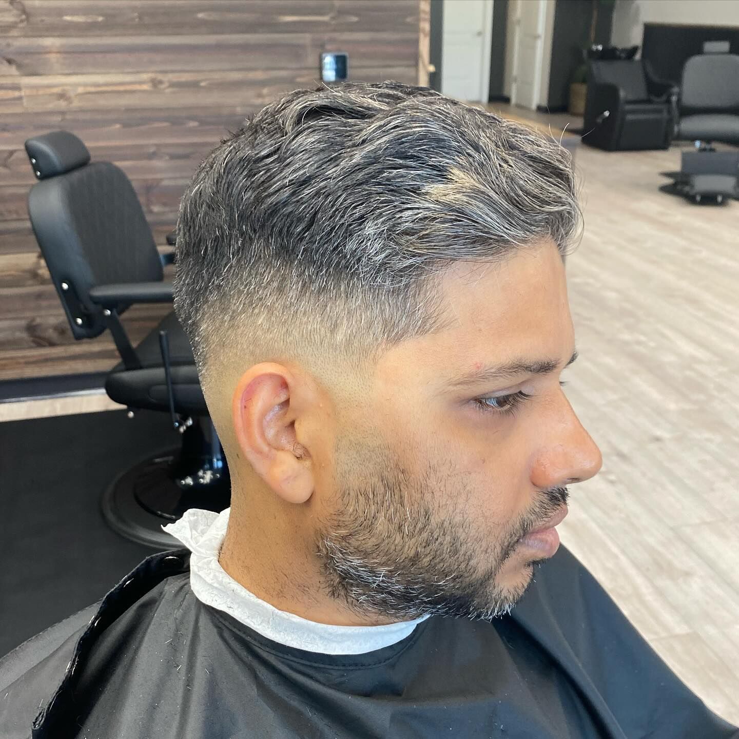 A man is getting his hair cut at a barber shop