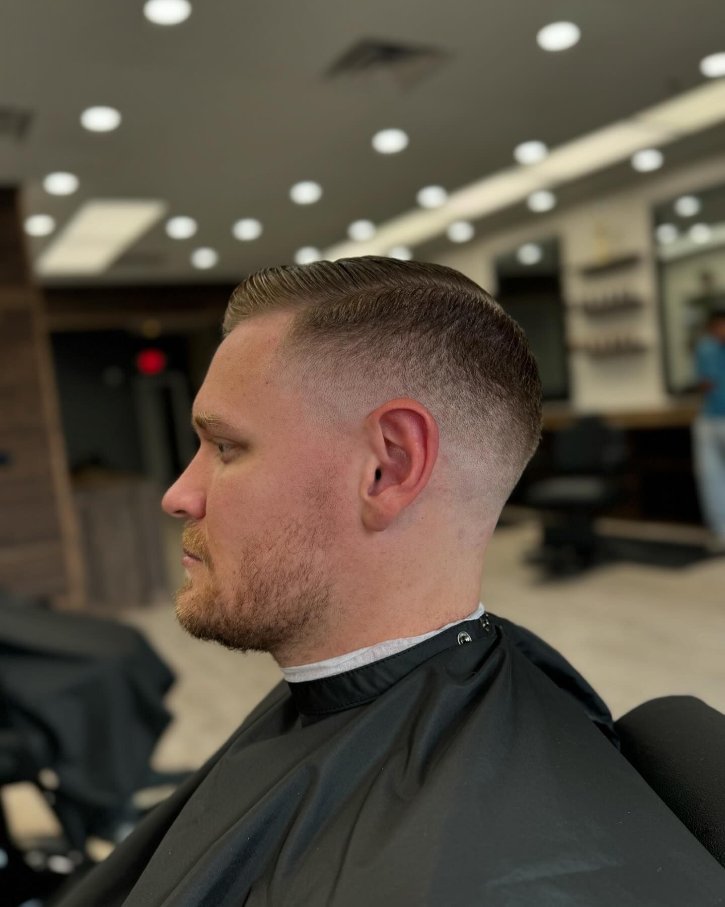 A man is getting his hair cut at a barber shop