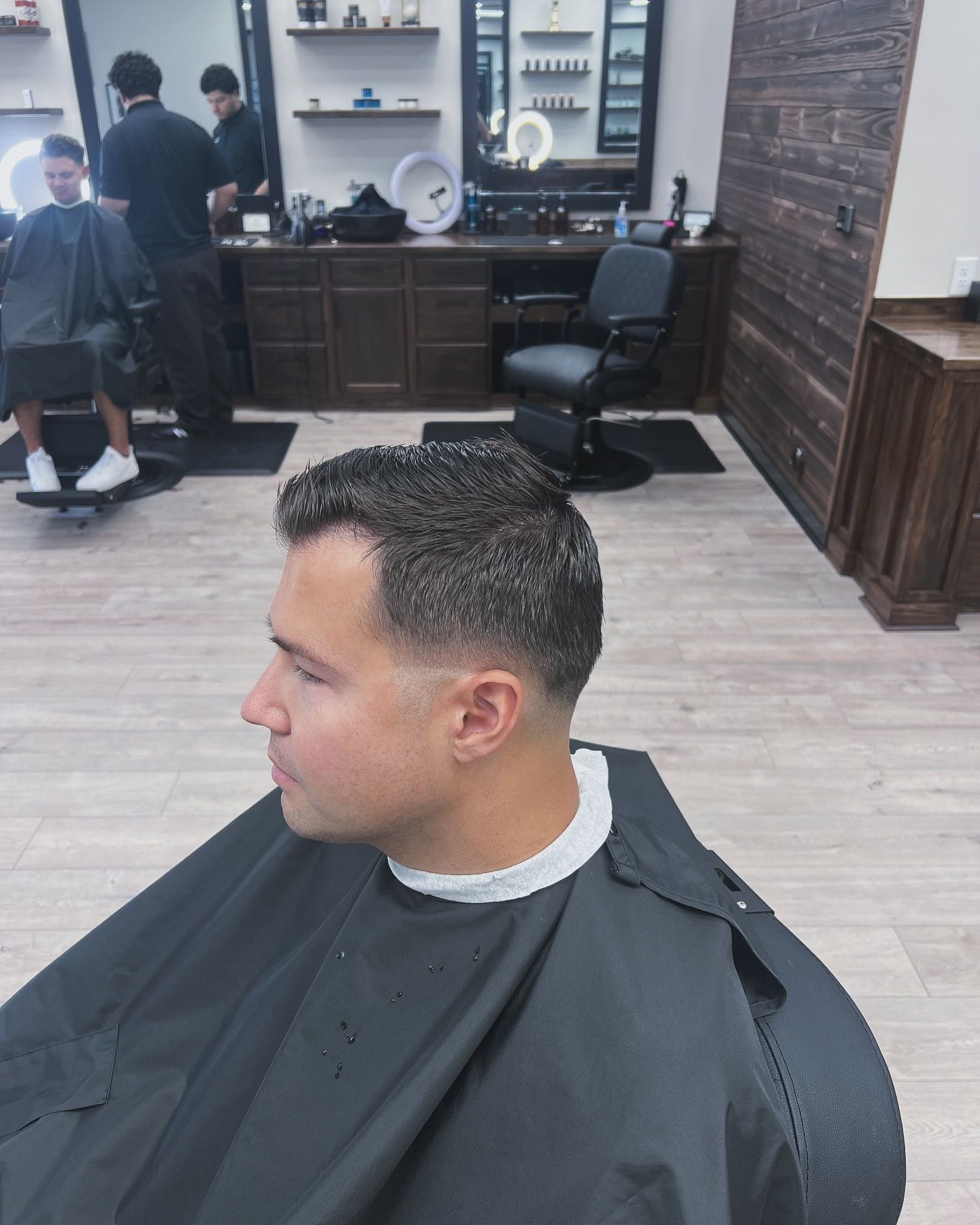 A man is getting his hair cut at a barber shop