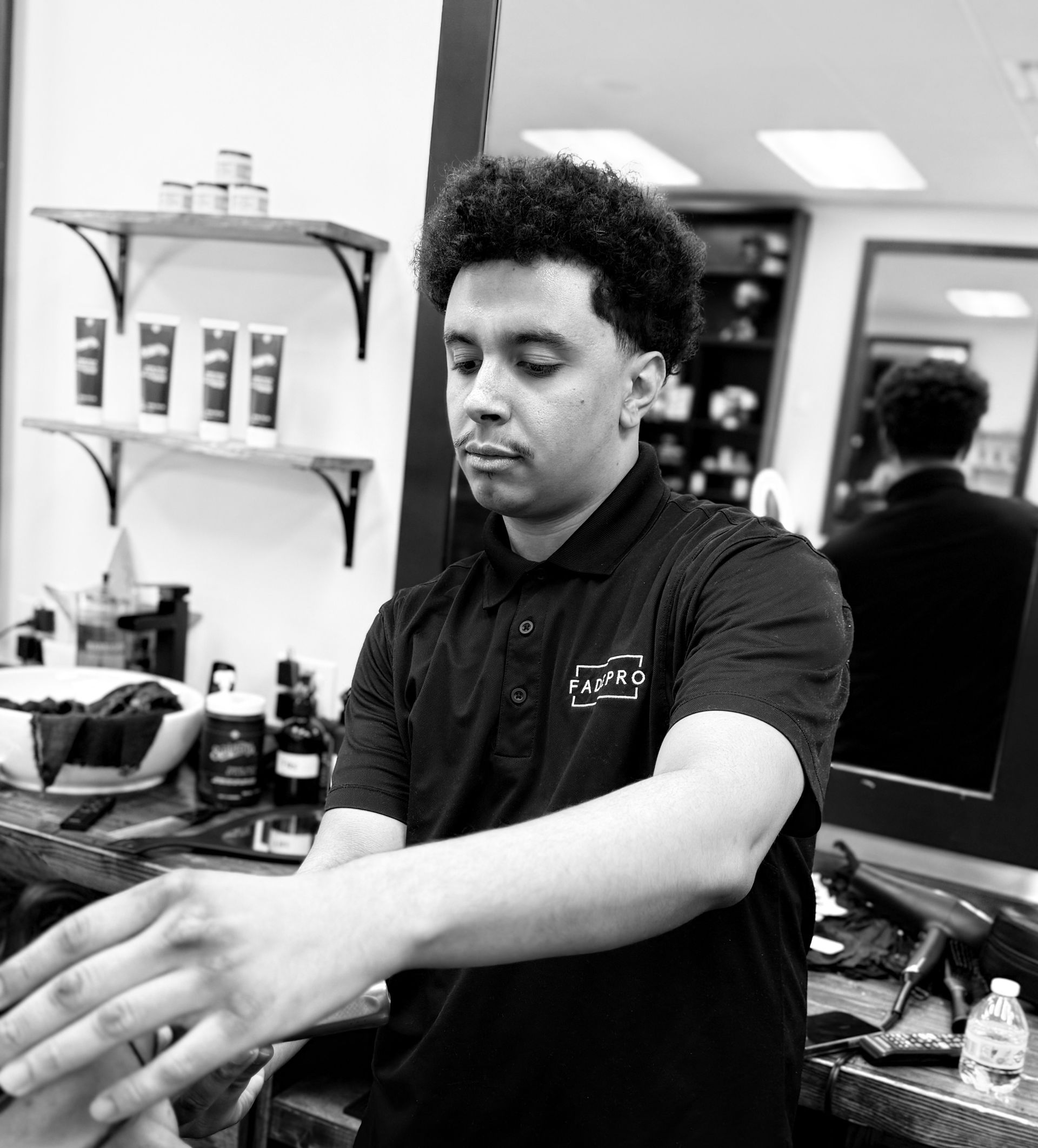A woman is cutting a man 's hair in a barber shop.